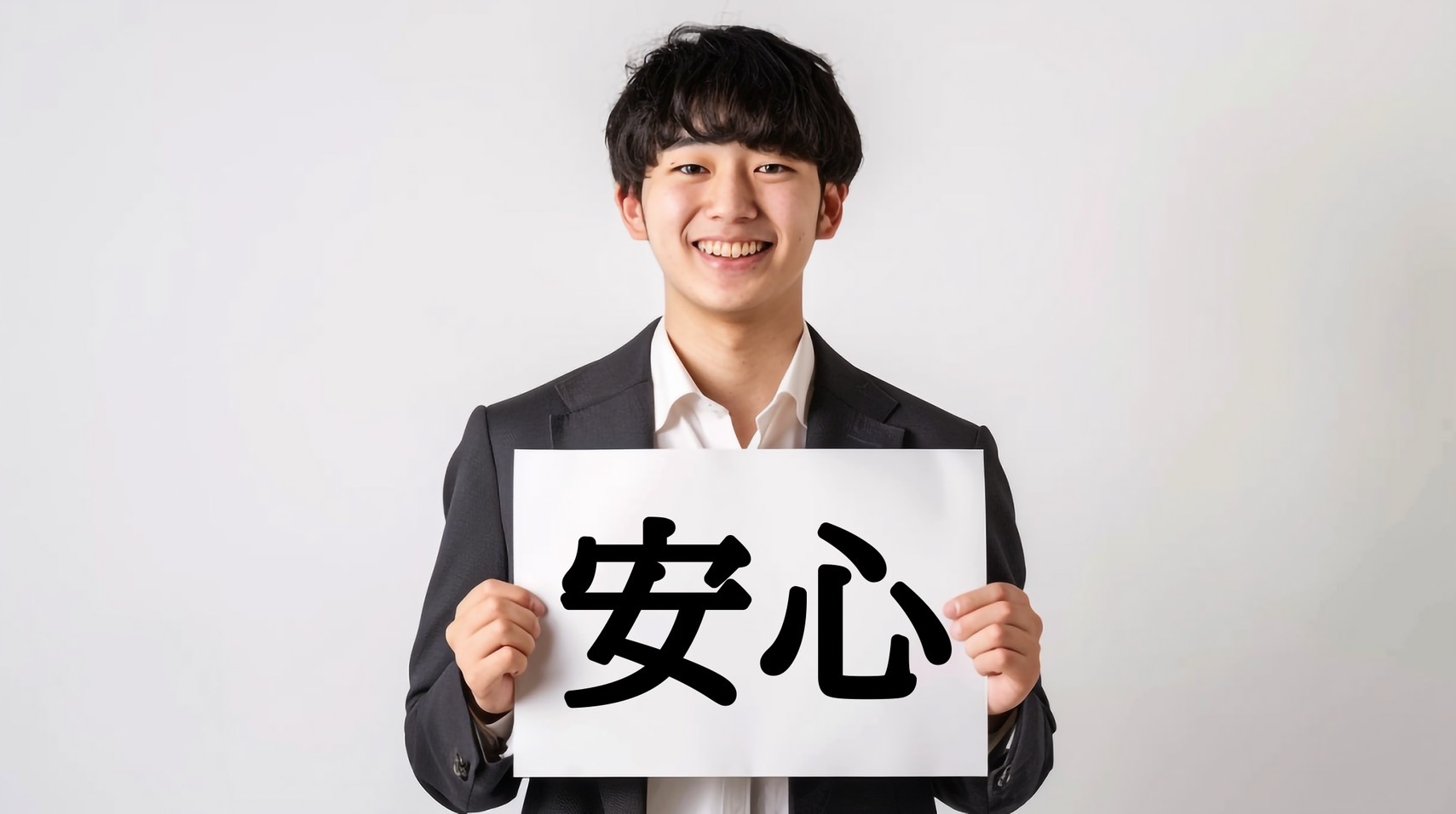 安心と書かれたプラカードを掲げた男性